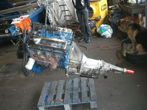 1972 Ford Ranchero - A Ford Ranchero engine and transmission assembly is suspended by chains in a garage.