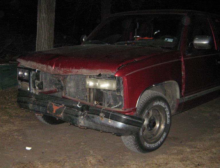 Red pickup truck front view, damaged bumper and grille