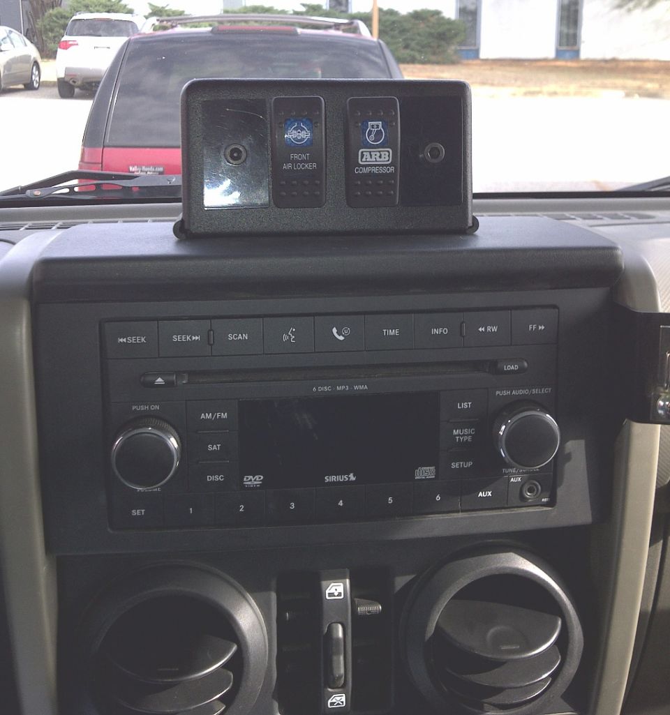 2007 Jeep Wrangler interior showing ARB air compressor and front air locker control panel above the radio