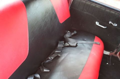 1991 Ford LTD Crown Victoria - The interior of a car features two-tone red and black seats and a black door panel with chrome handles.