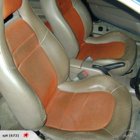 1993 Mazda MX-3 - Close-up of the tan and orange interior seats, showing wear on the leather bolsters.