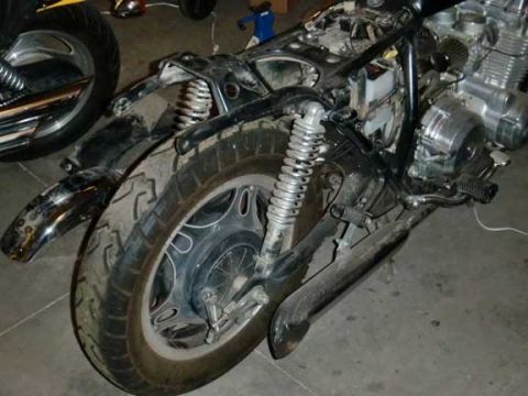1980 Honda CB750 - The motorcycle is partially disassembled, showing its frame, engine, and rear wheel assembly.