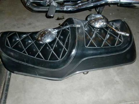 1980 Honda CB750 - A black motorcycle seat with white stitching and two chrome mirrors is shown.