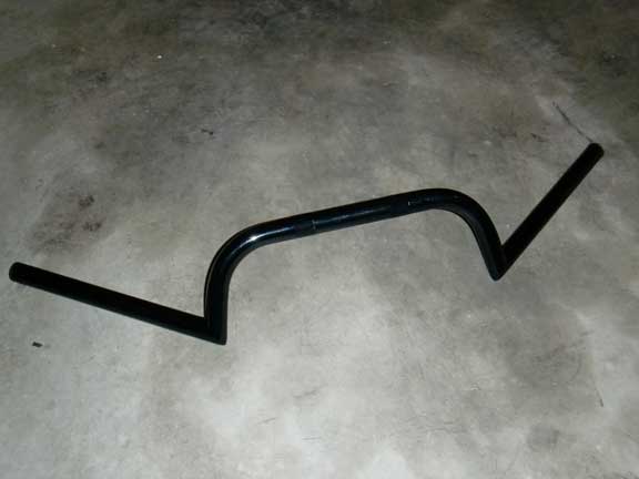 Black motorcycle handlebars on a concrete surface