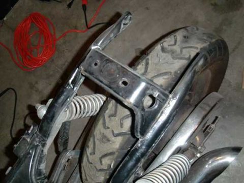 1980 Honda CB750 - Close-up of a motorcycle's rear frame section and tire, with electrical wiring nearby.