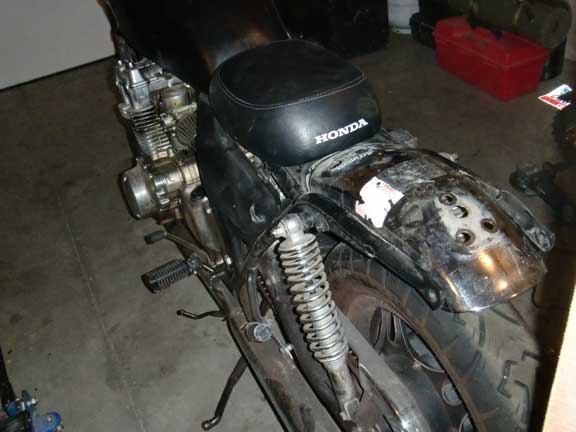 Black motorcycle rear fender with HONDA seat visible
