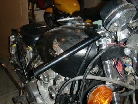 1980 Honda CB750 - A close-up view of a motorcycle's engine and fuel tank, with another motorcycle in the background.