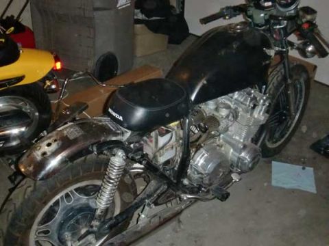 1980 Honda CB750 - A black motorcycle is parked indoors, its engine and side profile clearly visible. The motorcycle appears to be undergoing some work or res…