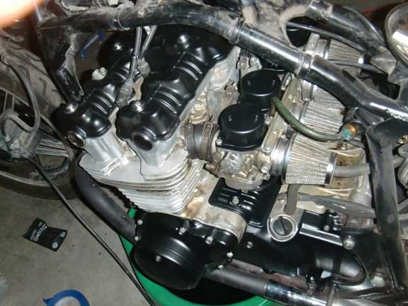 Motorcycle engine showing carburetors, air filters, and valve covers