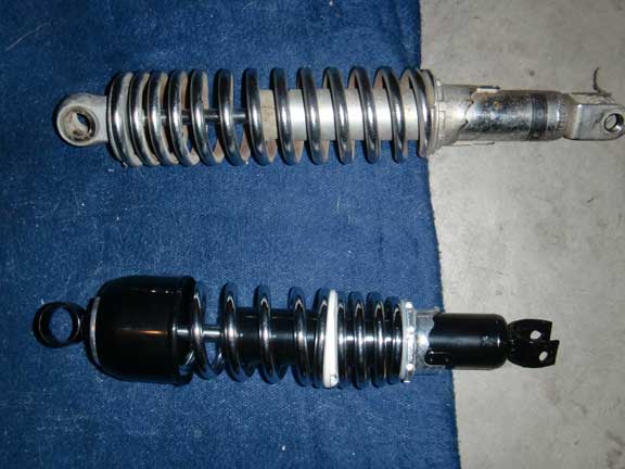 Two motorcycle shock absorbers, one chrome and one black