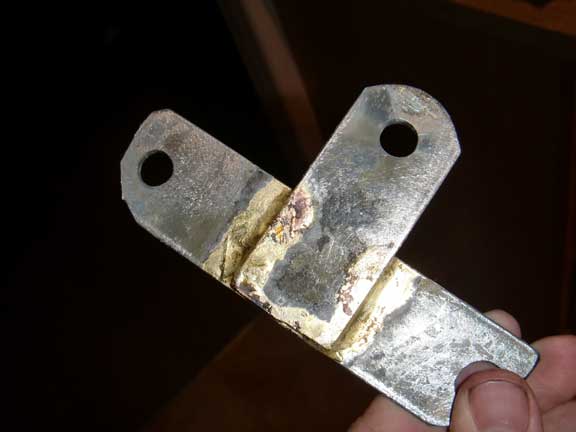metal bracket with two holes and some discoloration