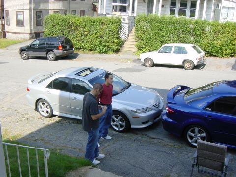 2003 Mazda 6 - Two men stand near a silver 2003 Mazda 6 sedan parked next to a blue Mazda 6.