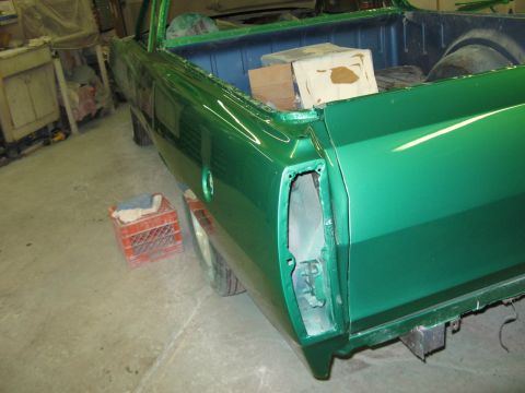 1971 Ford Ranchero - A green pickup truck is in a workshop, with its rear taillight assembly removed for work.