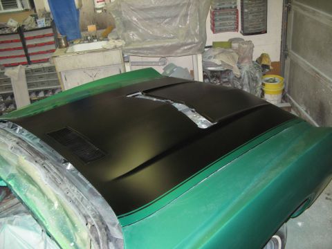 1971 Ford Ranchero - The hood of a 1971 Ford Ranchero is shown with a black matte finish and racing stripes, likely during a painting process.