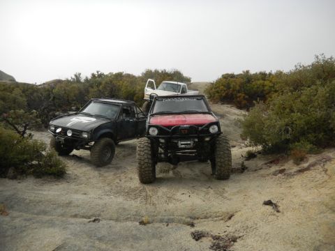 1997 Ford Ranger - Modified trucks are parked on a dirt trail in a rocky, arid environment.