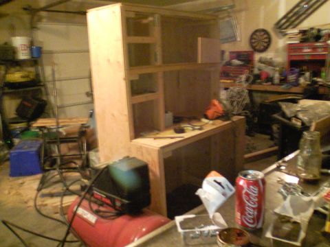 1989 Ford Bronco - A cluttered garage features an unfinished wooden cabinet, an air compressor, and various tools, with a Coca-Cola can prominently displayed…