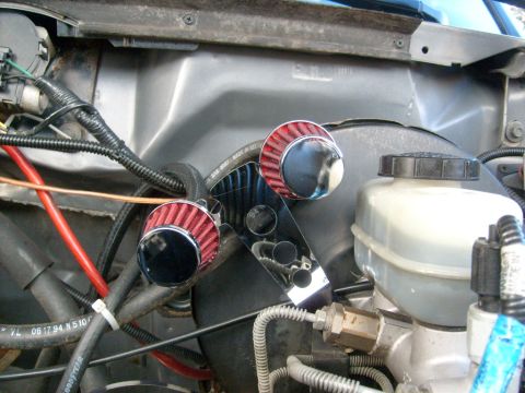 1986 Ford Bronco - Close-up of engine bay components, including aftermarket air filters and brake fluid reservoir.