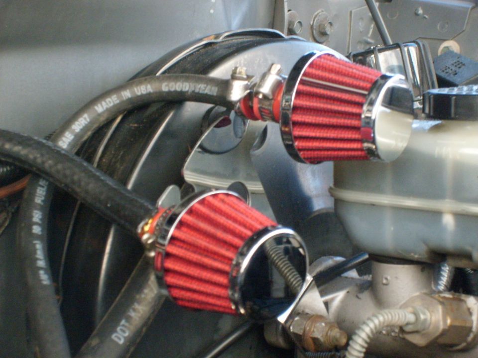 Engine bay with two red cone air filters and Goodyear hose