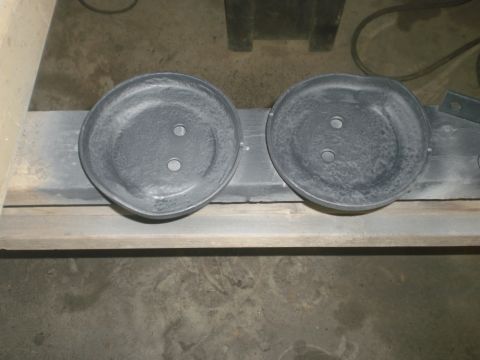 1995 Ford Bronco - Two brake dust shields are shown, likely for a vehicle's braking system, resting on a wooden plank.