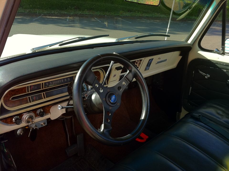 Interior shot of a vintage Ford truck, showing the dashboard, steering wheel, and seats