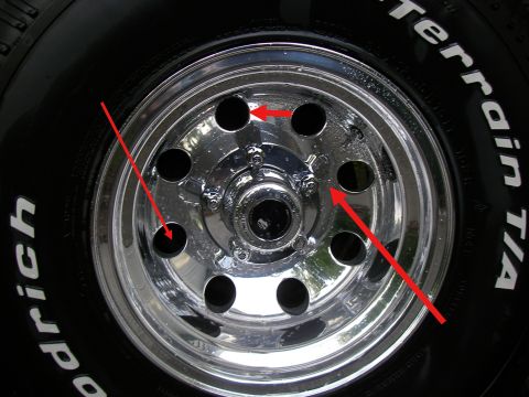 1990 Ford Bronco - Close-up of a polished aluminum eight-hole wheel wrapped in a BFGoodrich All-Terrain T/A tire with raised white lettering, annotated with t…