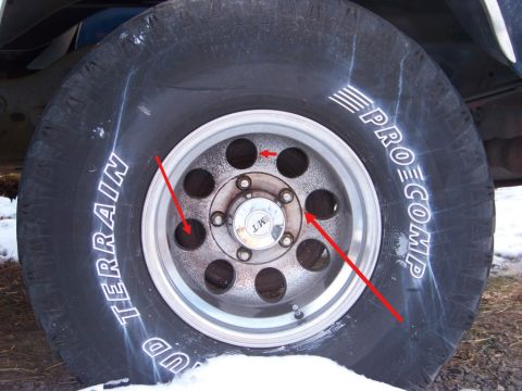 1990 Ford Bronco - Close-up of a Pro Comp Mud Terrain tire with raised white lettering mounted on a polished eight-hole aluminum wheel with a five-lug hub and…