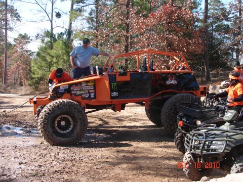 1987 Ford Bronco - Off-road buggy and ATVs in a wooded area with people present.
