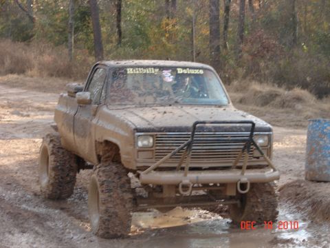 1987 Ford Bronco - This heavily modified pickup truck is covered in mud, suggesting it's being used for off-road activities.