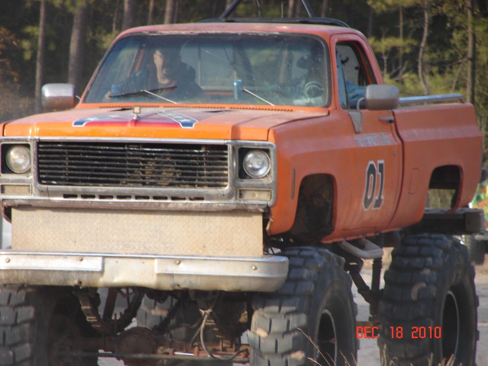 Orange lifted pickup truck with "01" on door and Confederate flag decal on hood