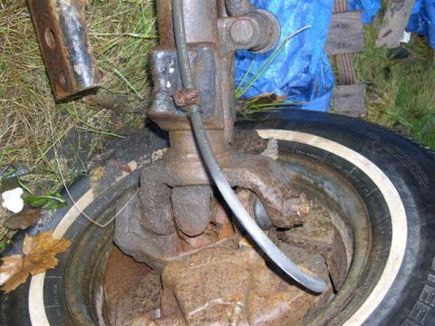 1982 Ford Bronco - Detail of a rusty front axle assembly and tire, likely from an older vehicle.