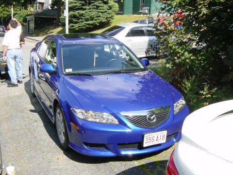 2003 Mazda 6 - A blue 2003 Mazda 6 sedan is parked on a street, seen from a 3q-front angle.
