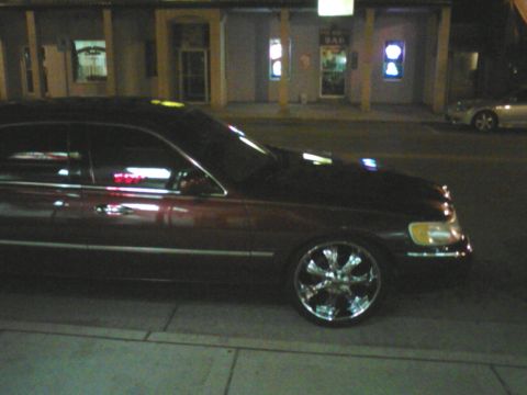 2000 Lincoln Town Car - Side view of a 2000 Lincoln Town Car at night, custom chrome wheels.