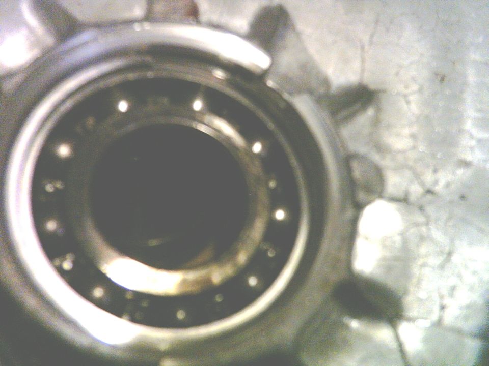 Close-up of a wheel bearing assembly with visible ball bearings and metal housing