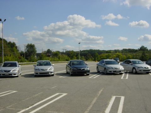 2003 Mazda 6 - Several Mazda 6 sedans are parked in a lot under a partly cloudy sky. The vehicle on the far right has a watermark for SuperMotors.net.