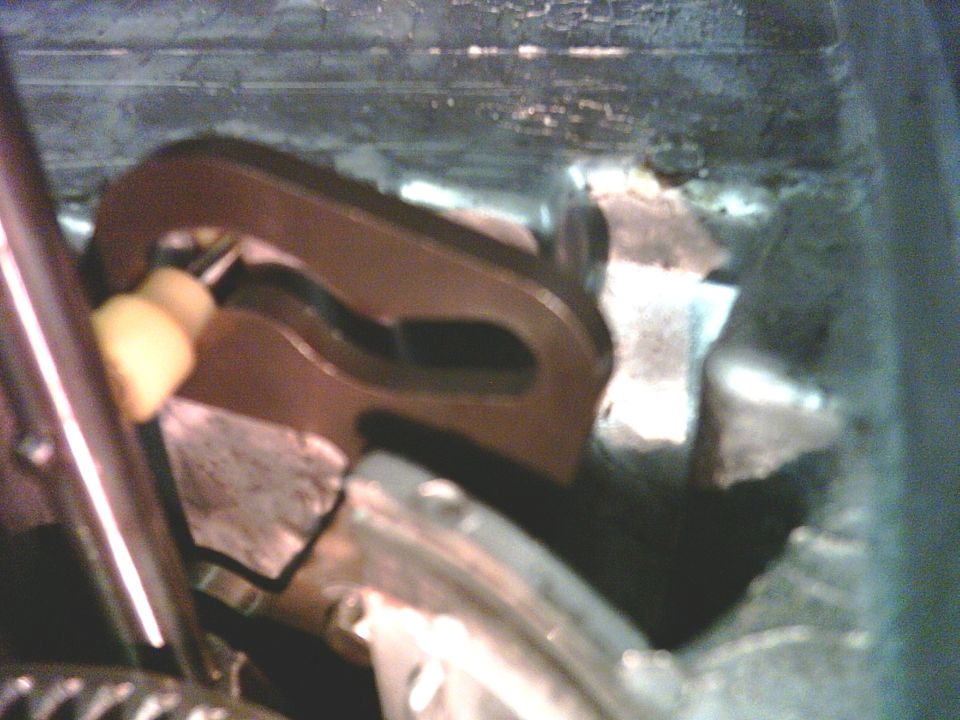 Close-up of a metal transfer case linkage mechanism with a yellow plastic component