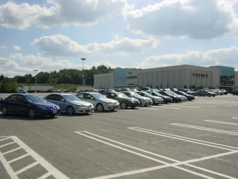 2003 Mazda 6 - A line of sedans, including a blue 2003 Mazda 6, are parked in a lot in front of a Filene's department store.