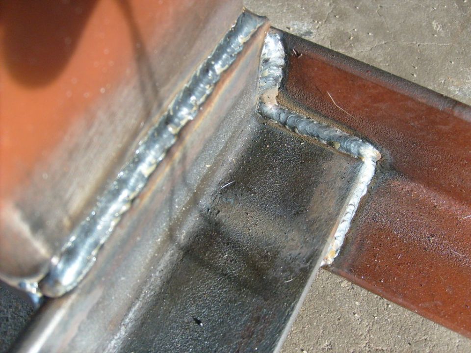 Close-up of welded metal pieces. Supermotors.net logo visible