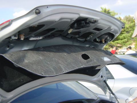 2003 Mazda 6 - The interior of a car's trunk is visible, with insulation and mechanical components exposed.