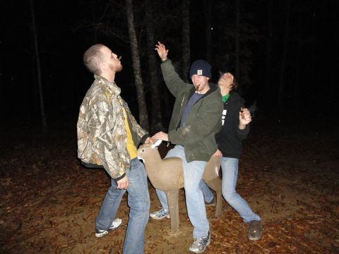 1989 Ford Bronco - Three men pose with a deer decoy in a dark, wooded area, with leaves on the ground.