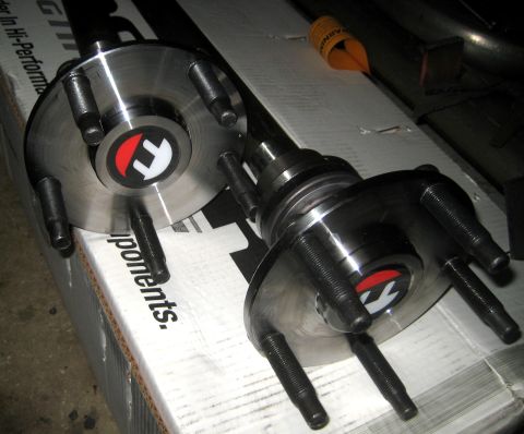 1996 Ford Bronco - Close-up of two automotive rear axle hubs with a circular logo on each.