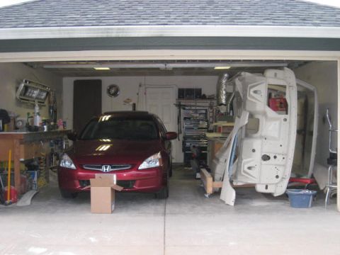 1976 Ford F-250 - A red Honda Accord is parked in a garage next to a disassembled car body.