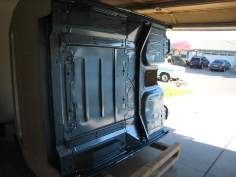 1976 Ford F-250 - The underside of a truck body is shown, with other vehicles visible in the driveway behind it.