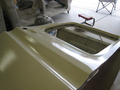 1976 Ford F-250 - A car door is shown with a primer coat, ready for paint, in a workshop setting.