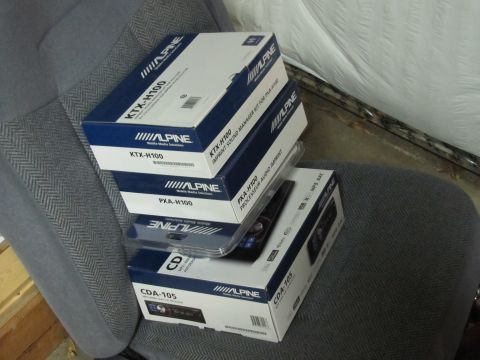 1993 Ford F-250 - Several Alpine car audio component boxes are stacked on a vehicle seat.
