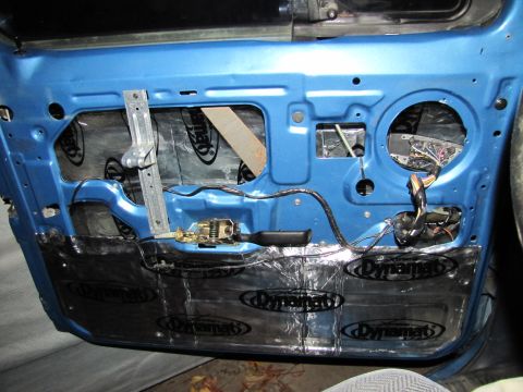 1993 Ford F-250 - Dynamat sound deadening installed on the interior of a blue car door, revealing internal components.