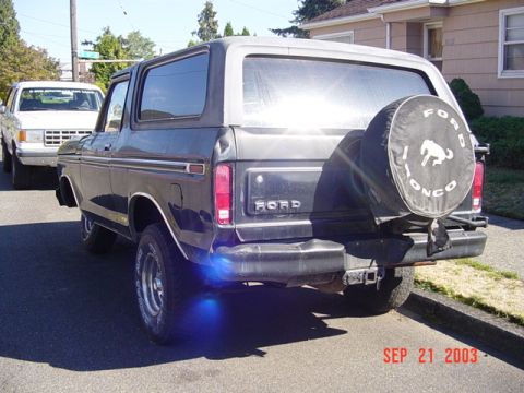 1979 Ford Bronco - This Ford Bronco has a spare tire cover with the Bronco logo. Another Ford truck is visible in the background.