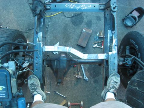 1976 Ford F-250 - A close-up view of a truck's frame and rear axle, with tools and welding equipment scattered around.