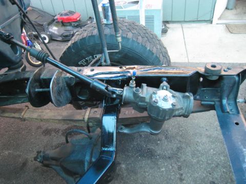 1976 Ford F-250 - The steering mechanism and frame of a vehicle are shown, with a large tire visible in the background.