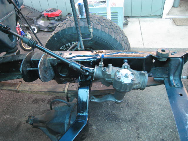 Close-up of a vehicle's frame, steering box, and part of a tire