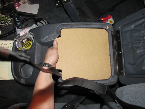 1993 Ford F-250 - A hand inserts a cardboard piece into a vehicle's center console, with a tape measure visible.